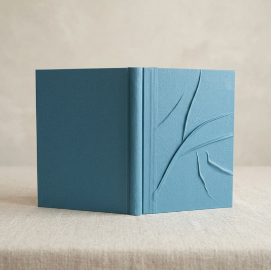 Carnet ou livre d’or bleu, couverture embossée avec motif végétal et tranche visible