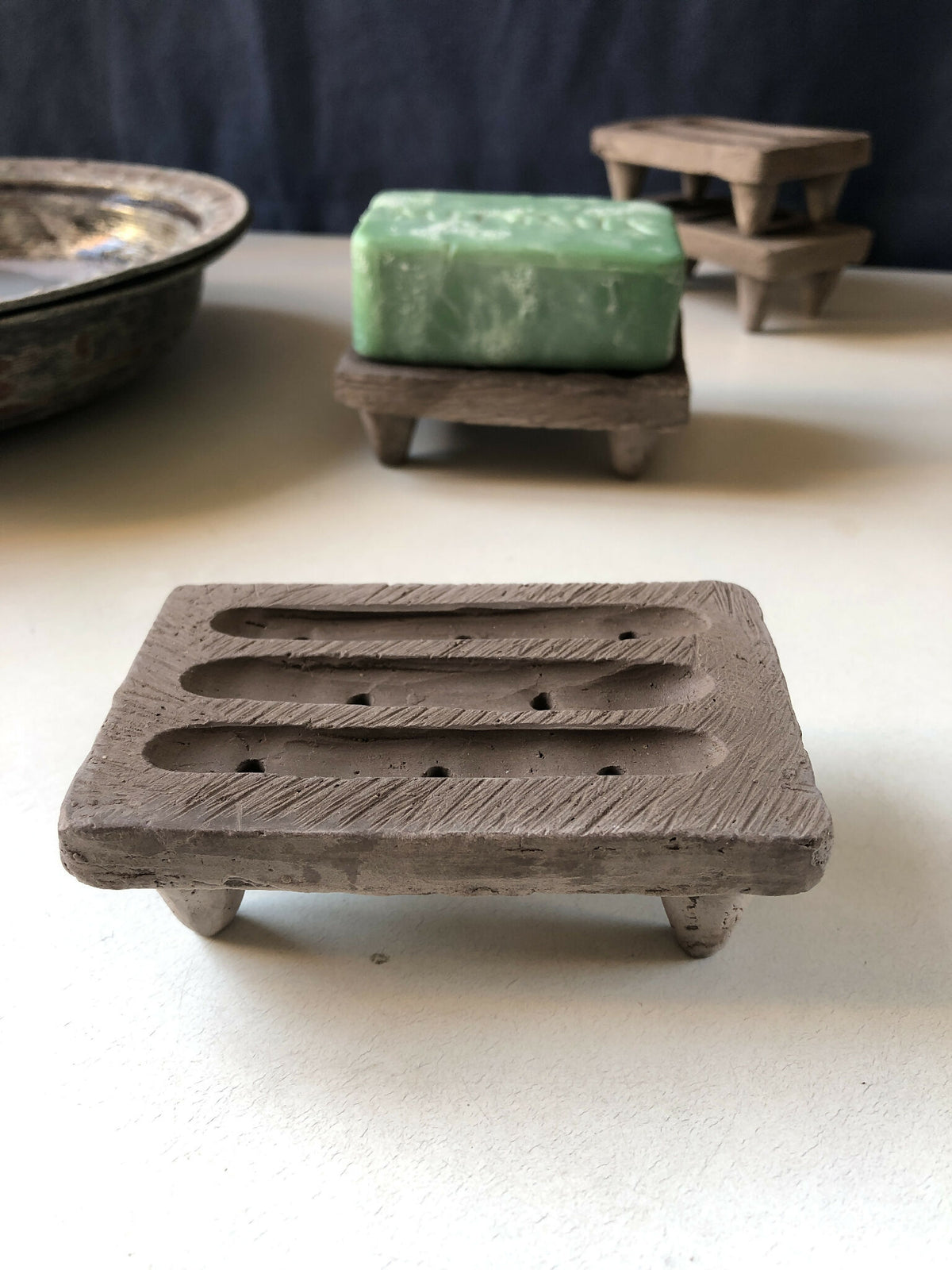 Porte-savon #4 en bois gris, plateau avec rainures, savon vert posé dessus