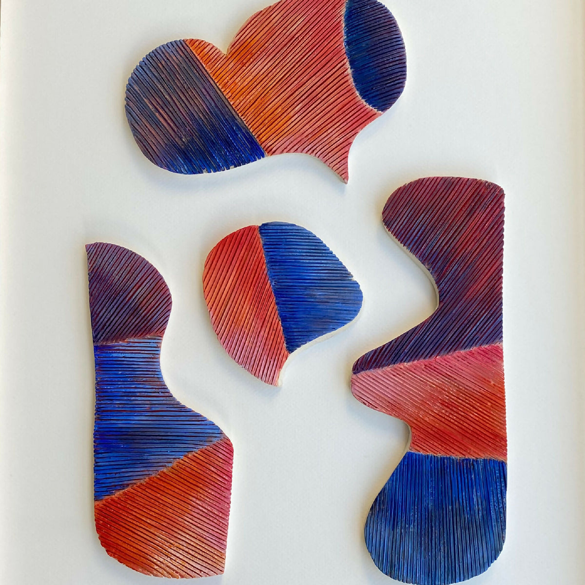 Tableau en relief Kokoro, gros plan : formes découpées orange, bleu et violet, textures striées.