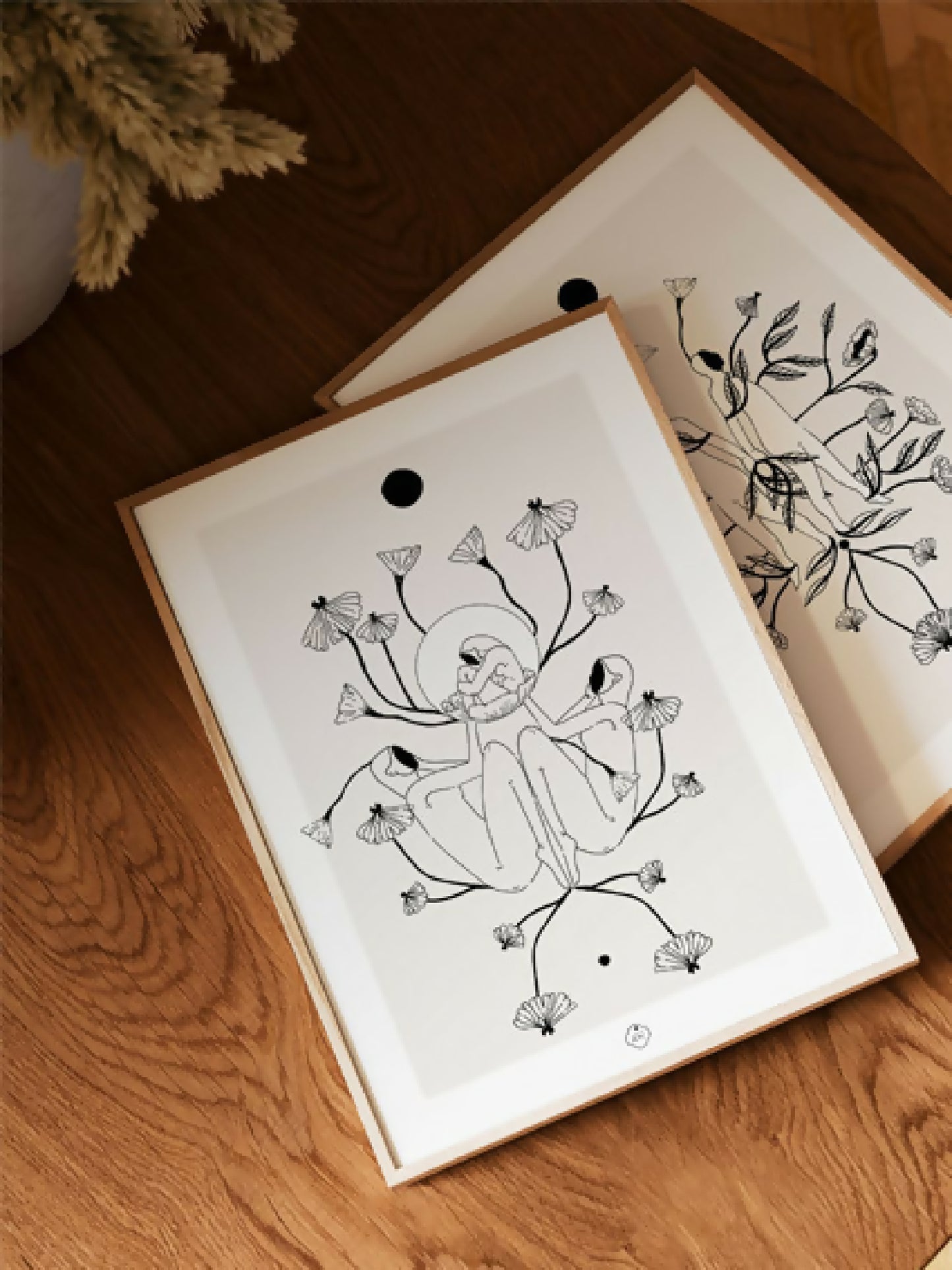 Illustration A4 à l’encre noire encadrée : silhouette centrale, fleurs et feuilles stylisées.