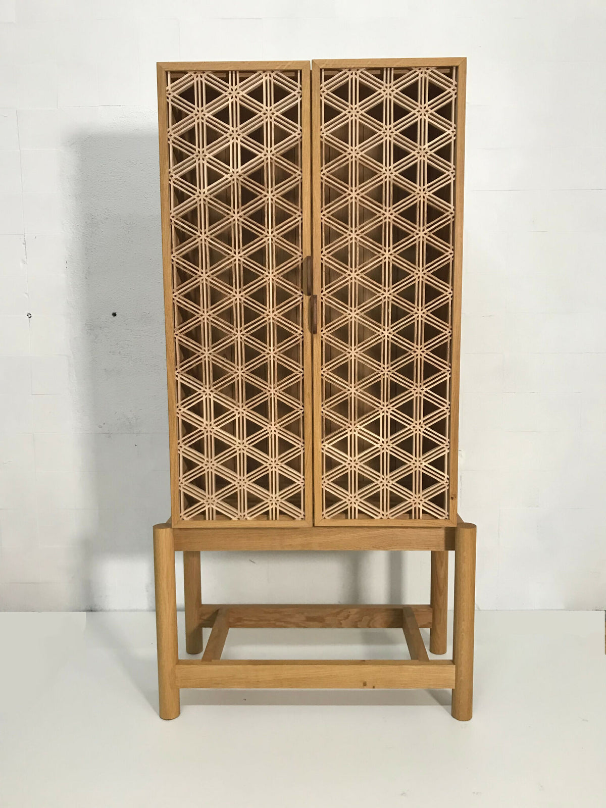 Meuble vitrine en chêne Goma, portes à motif croisillons et piètement bois.