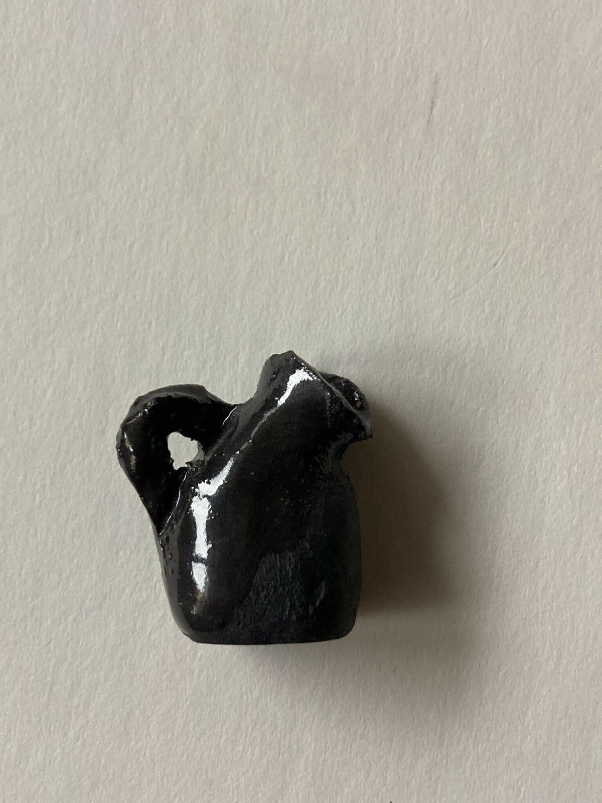Pendentif miniature en porcelaine noire en forme de pichet, vue rapprochée de l’anse