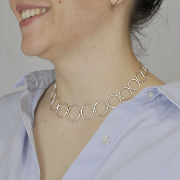 Collier à maillons ronds en métal argenté, porté autour du cou