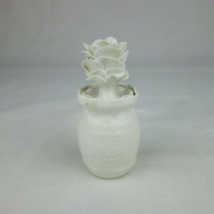 Vase en céramique blanc, fleurs en relief au sommet, vue entière centrée.