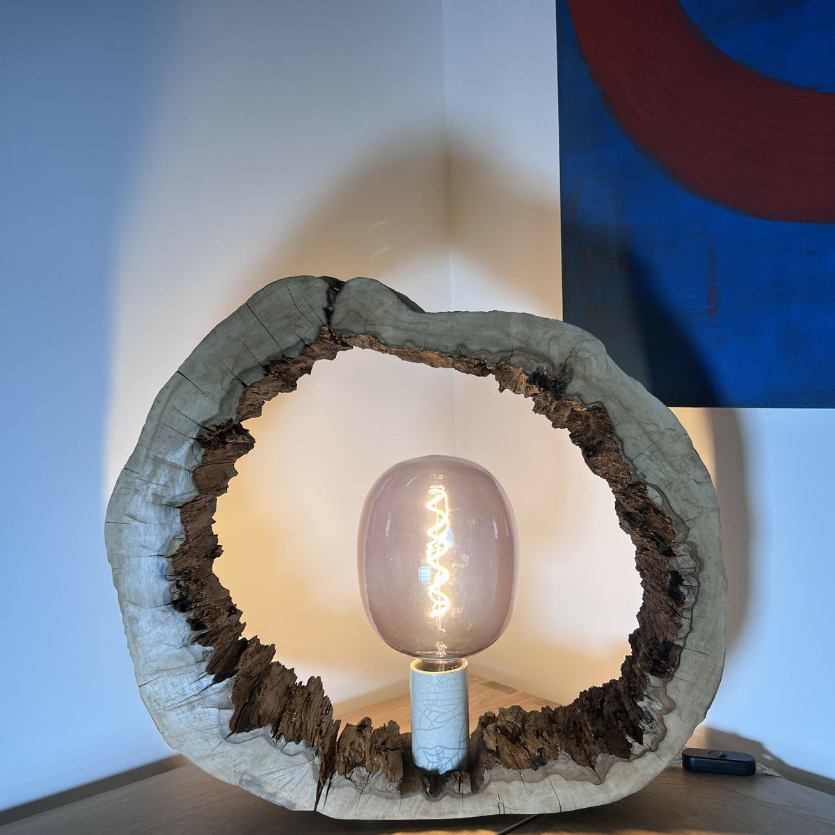 Sculpture lumineuse circulaire en résine/bois sombre avec ampoule Edison et socle bleu