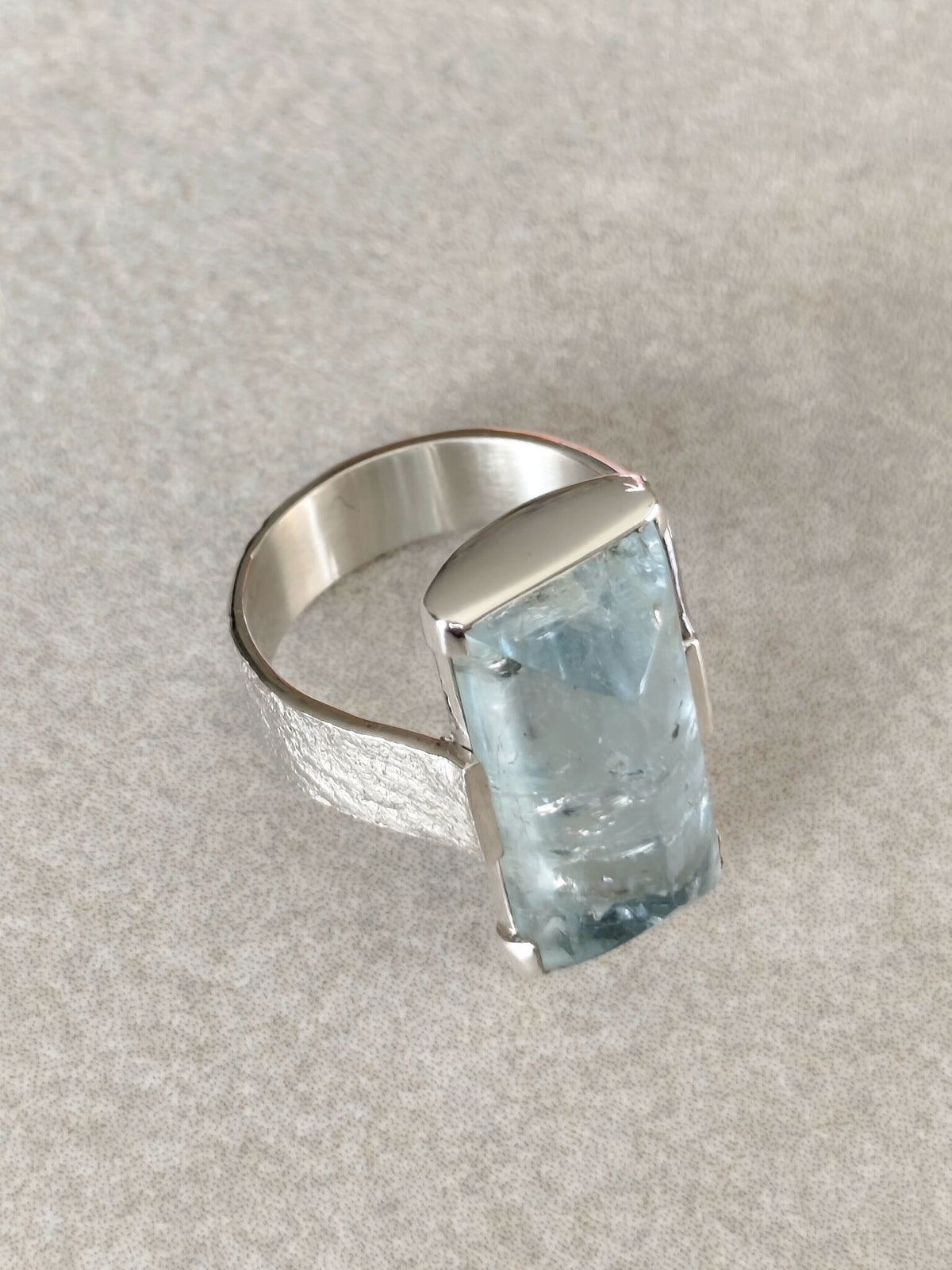 Bague en topaze bleu clair rectangulaire, monture argent, vue de dessus.