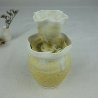 Vase en céramique jaune pâle, intérieur vert visible, col fin évasé et bord blanc