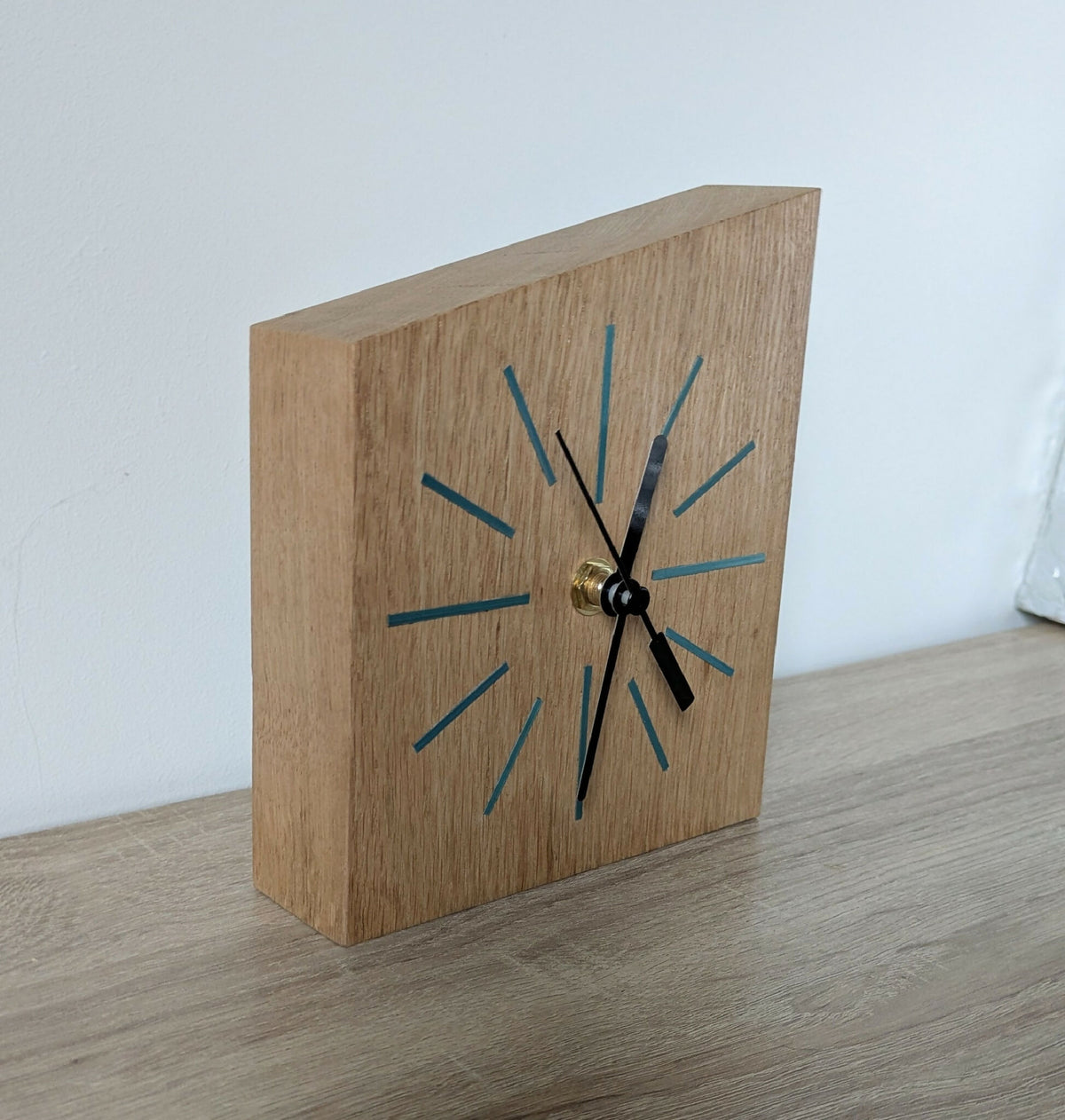 Horloge de bureau en bois avec repères bleus, centre doré et aiguilles noires