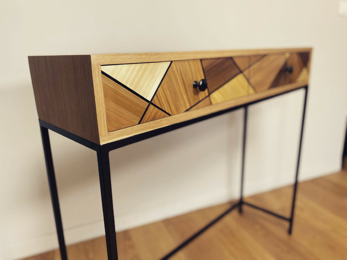 Console en chêne vue de biais, façade à losanges avec boutons noirs, pieds noirs