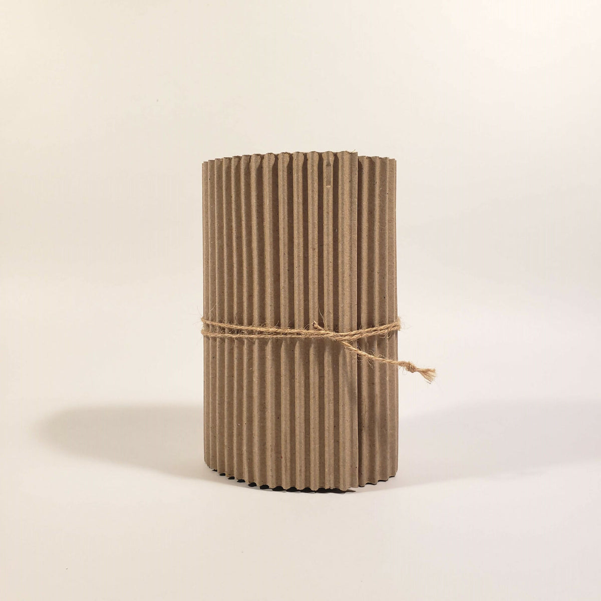 Tube en carton ondulé beige avec ficelle, emballage cylindrique