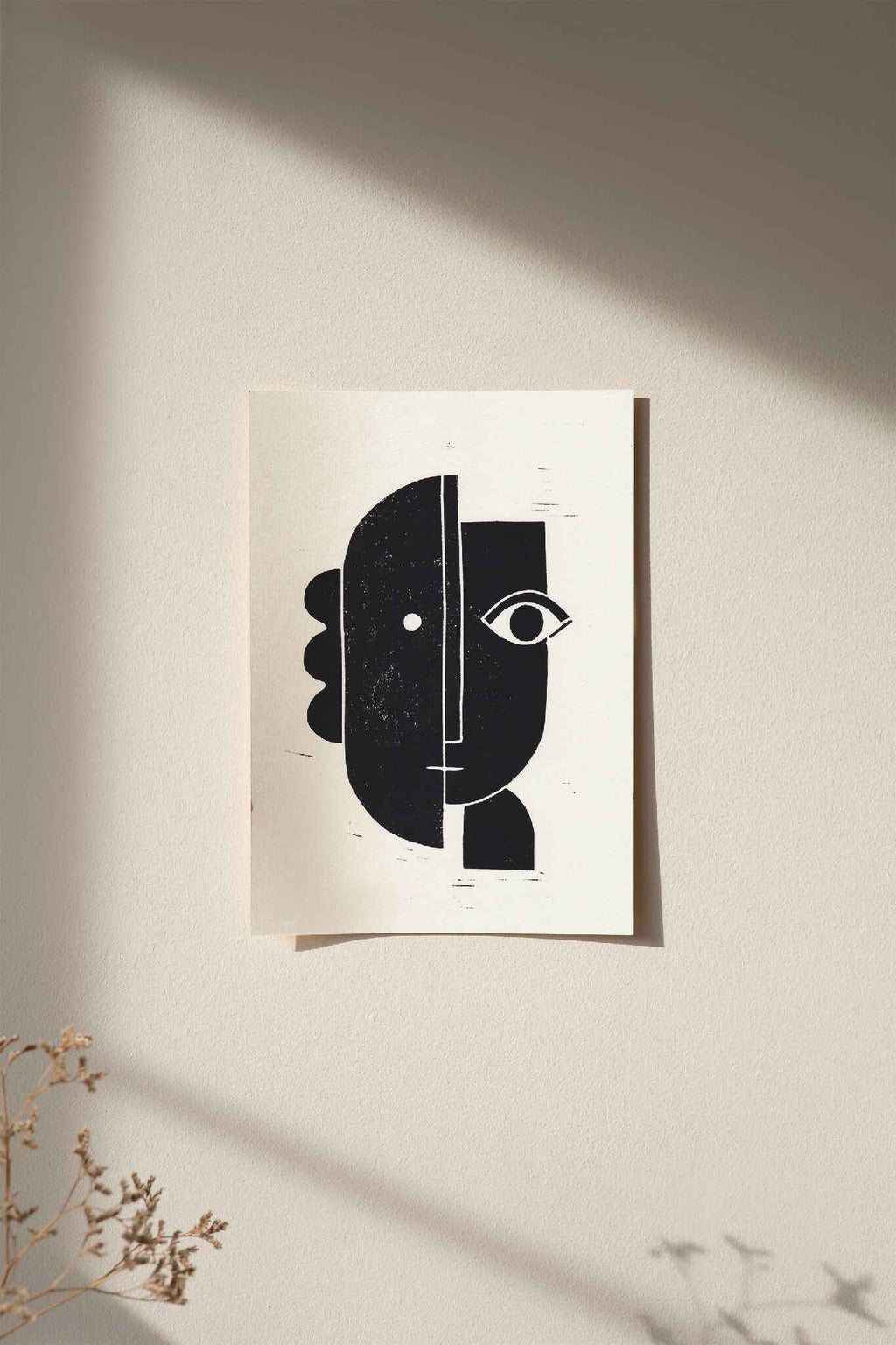 Linogravure encadrée, composition abstraite noir et blanc, cadre bois clair sur fond clair.