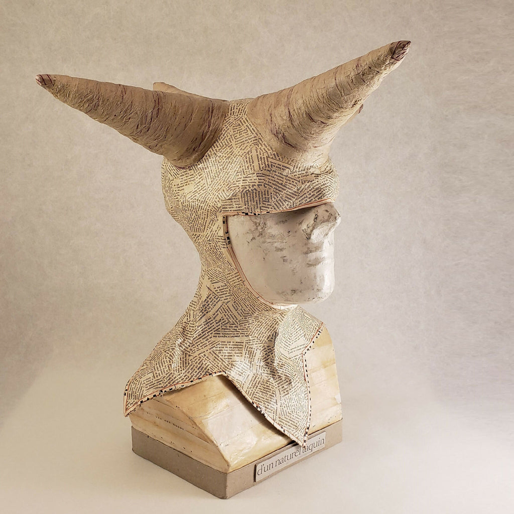 Buste sculpté beige à cornes, visage en demi-profil, inscription « d’un naturel taquin » sur la base