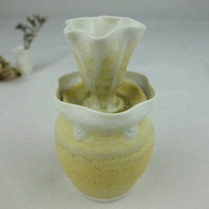 Vase en céramique jaune pâle, ouverture large et bord ondulé, intérieur vert foncé