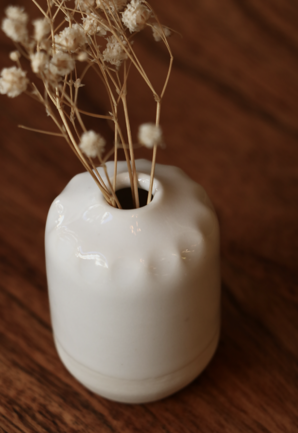 Mini-vase en porcelaine blanche, vue de dessus avec tiges florales, surface brillante.