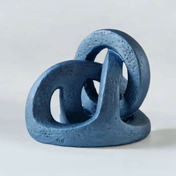 Sculpture abstraite en résine bleue, formes d’anneaux empilés sur base.