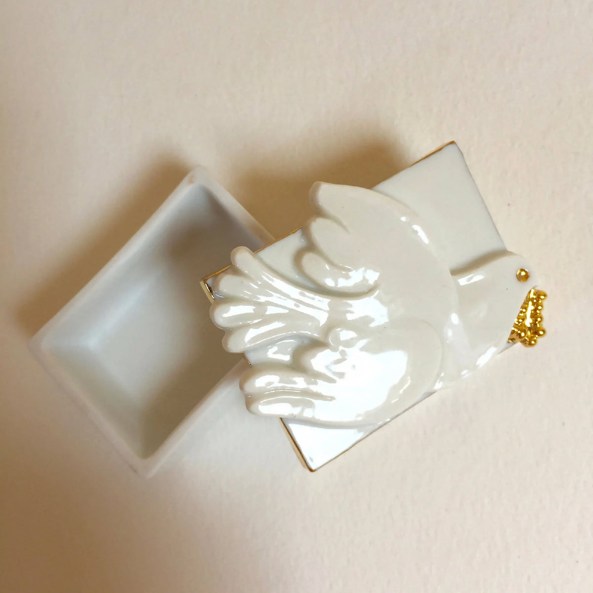 Boîte à bijoux colombe en porcelaine blanche, relief des ailes et détails dorés.