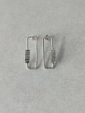 Boucles d’oreilles rectangulaires argentées, rayures verticales sur le centre.