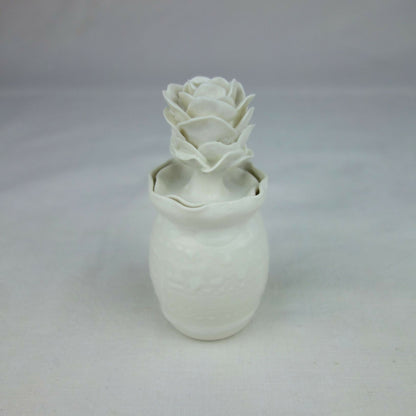 Vase en céramique blanc avec décoration florale en relief, vue de face légère.