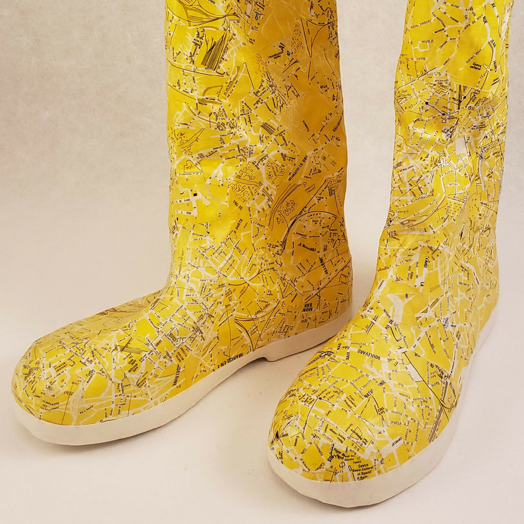 Bottes jaunes à tige haute, gros plan du motif, semelle blanche et couture visible.