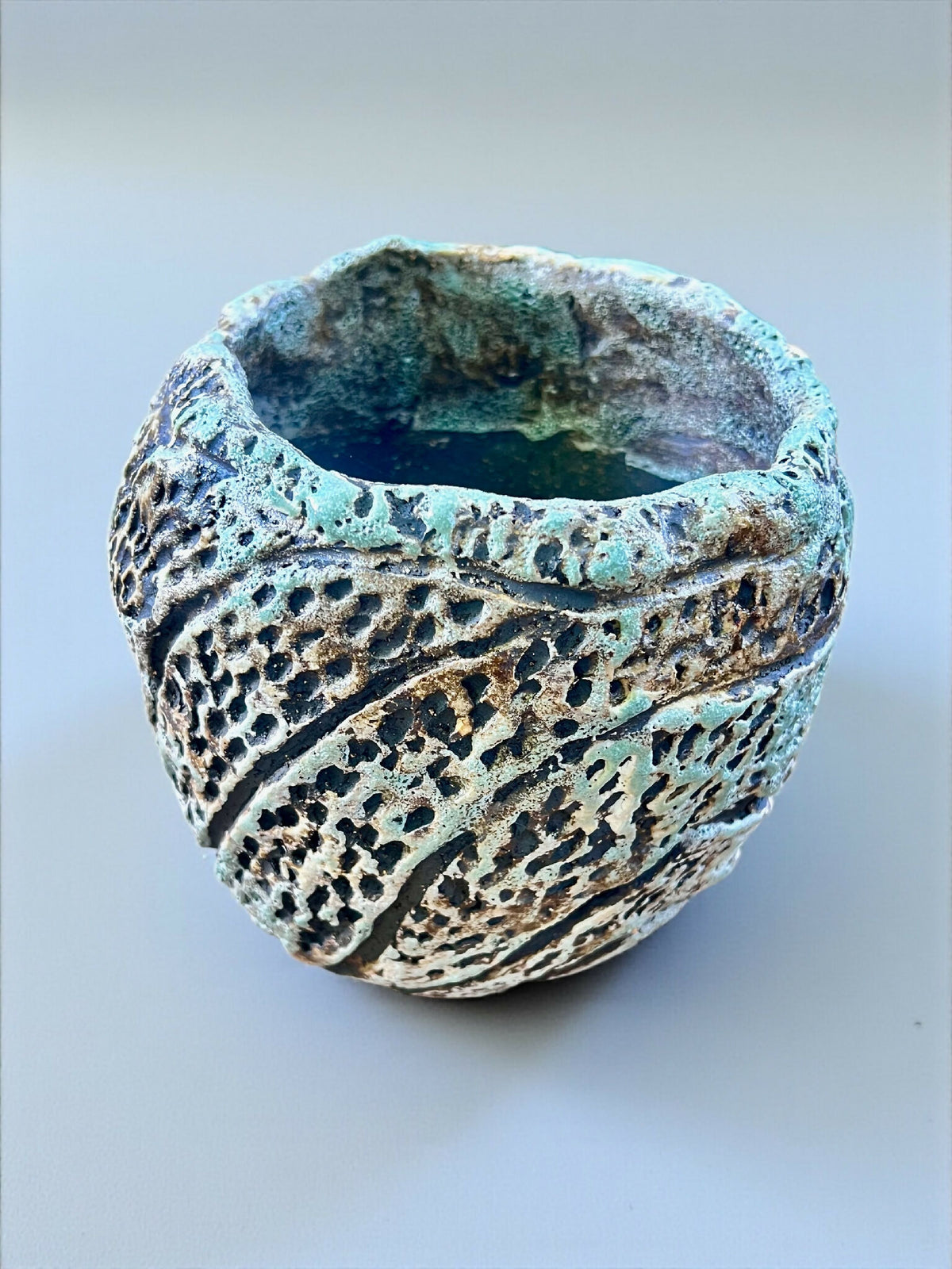Pot en grès sculpté avec ouverture, intérieur vert bleuté, reliefs à trous