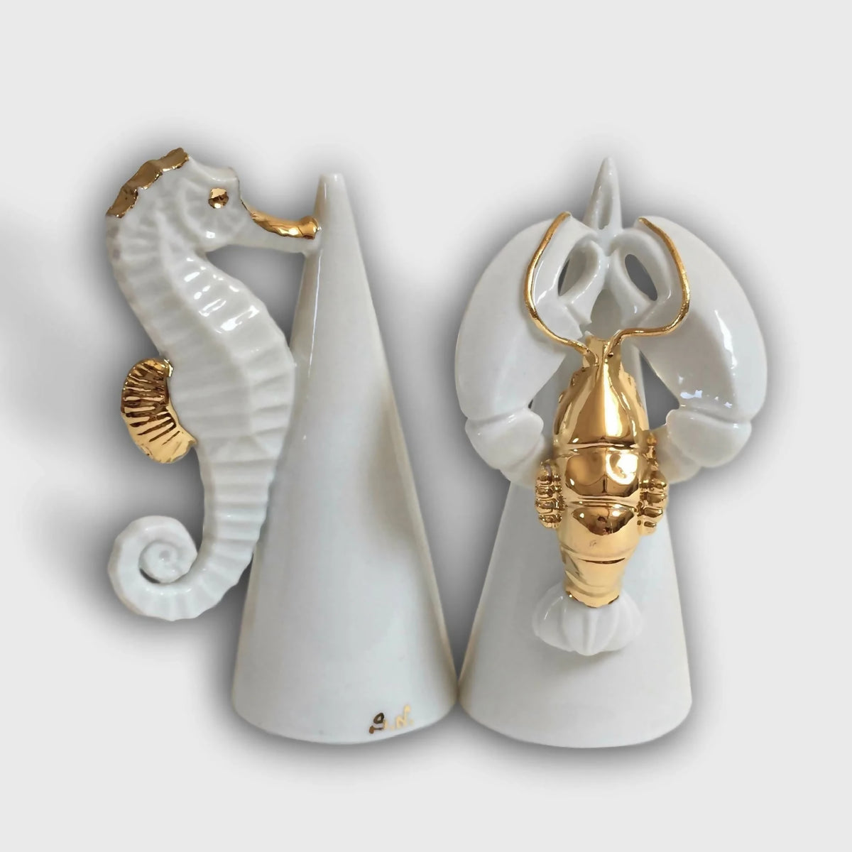 Salier et poivrier en porcelaine blanche, motifs homard et hippocampe dorés