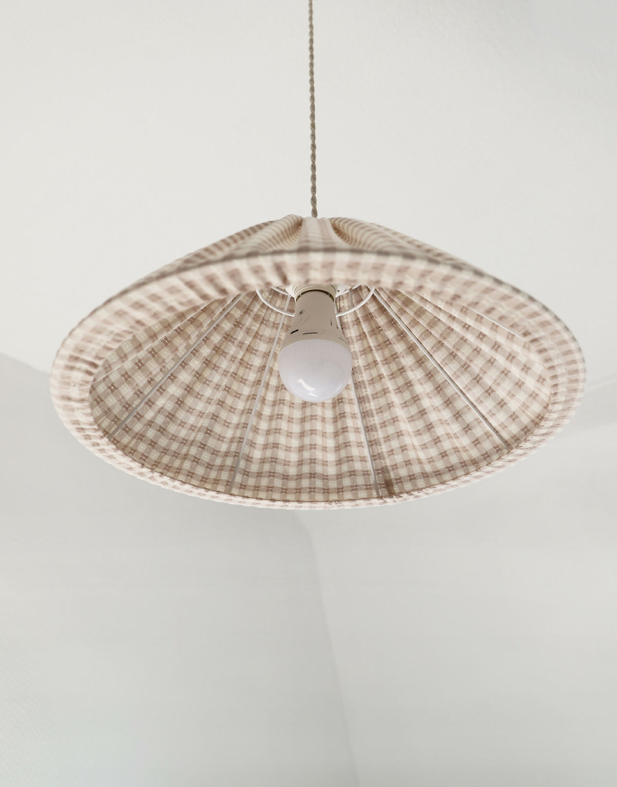 Suspension conique vichy beige clair, petits carreaux, douille blanche au centre.