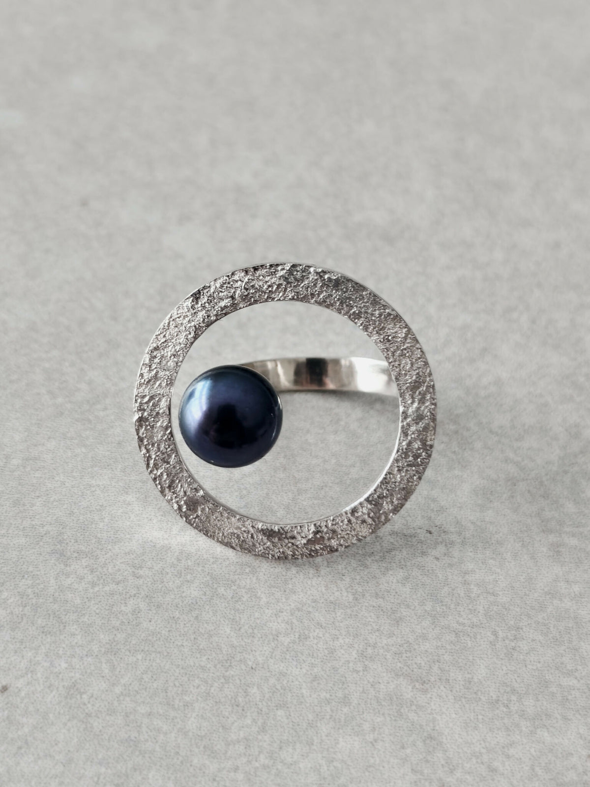 Bague ovale argentée texturée avec cabochon bleu foncé au centre