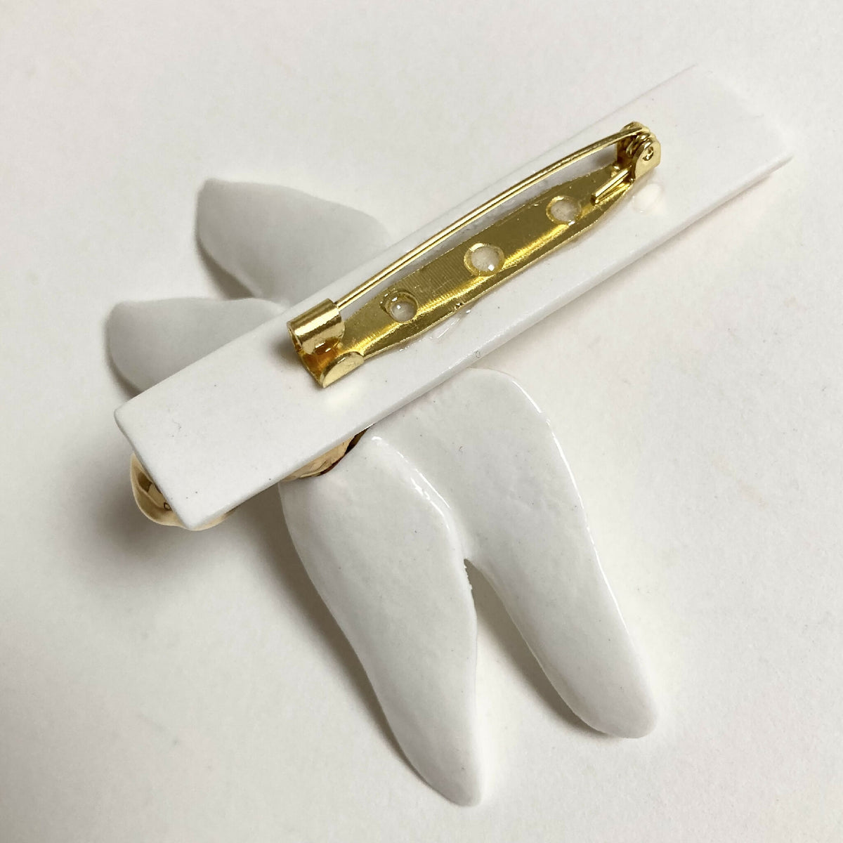 Broche libellule sur motif d’aile, barrette dorée et ailes blanches en relief