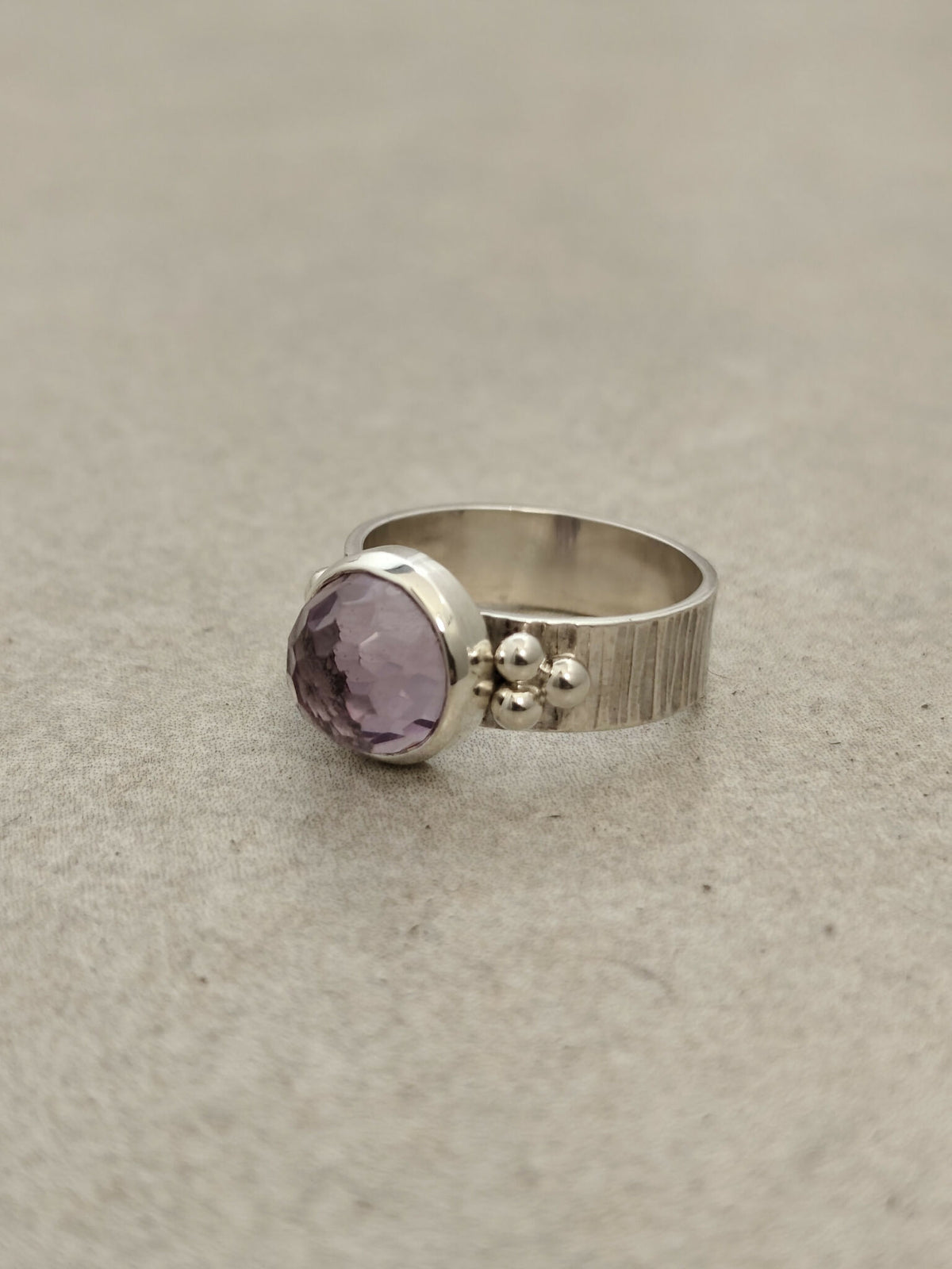 Bague en argent avec pierre améthyste ovale violet, profil fin et décor de billes.