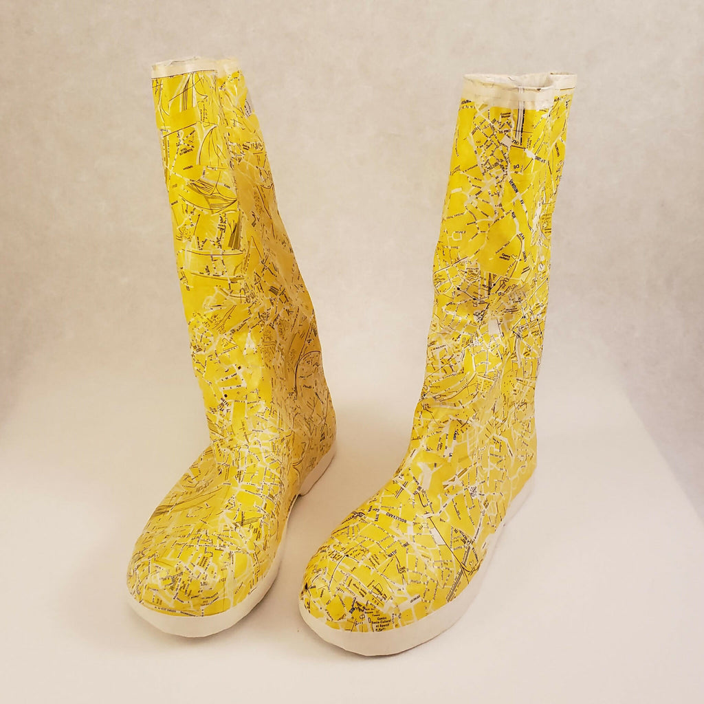 Bottes jaunes à tige haute, motif éclaté, semelle blanche épaisse, talon bas.
