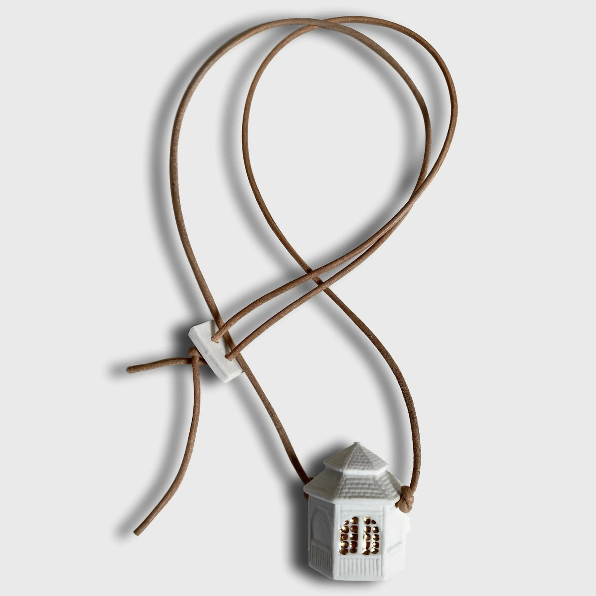 Collier avec pendentif maison en émail blanc et cordon brun, nœud décoratif