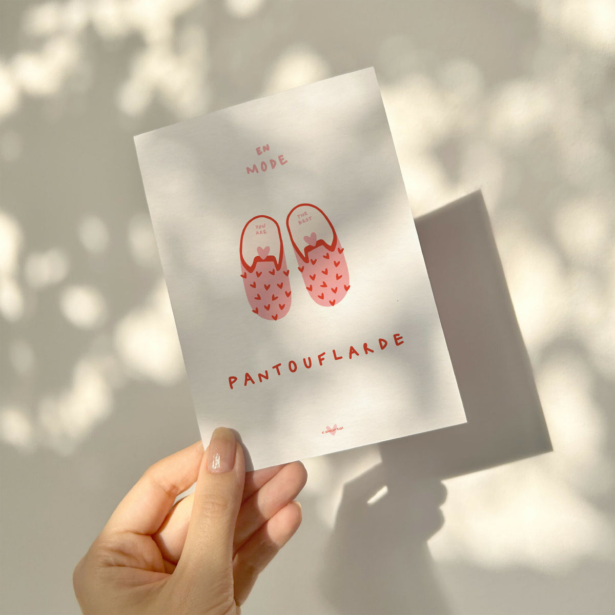 Carte de vœux blanche tenue en main, pantoufles rouges et « PANTOUFLARDE »