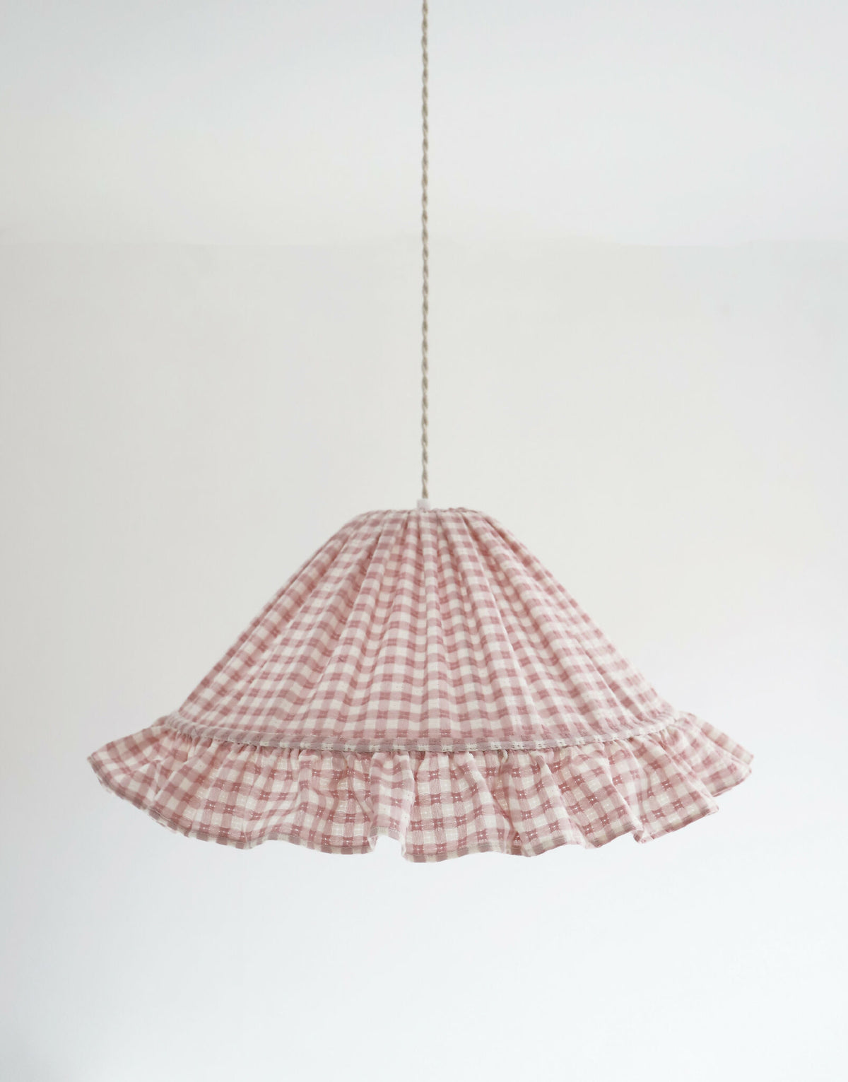 Suspension conique à petits carreaux rose avec volant froncé et haut fripé.