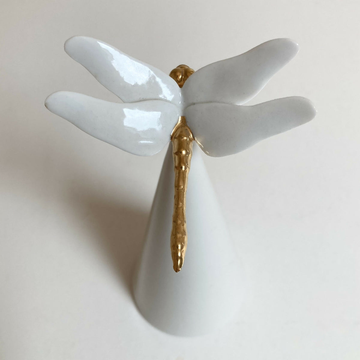 Centre de table cône blanc, motif ailes blanches et tige dorée, vue rapprochée