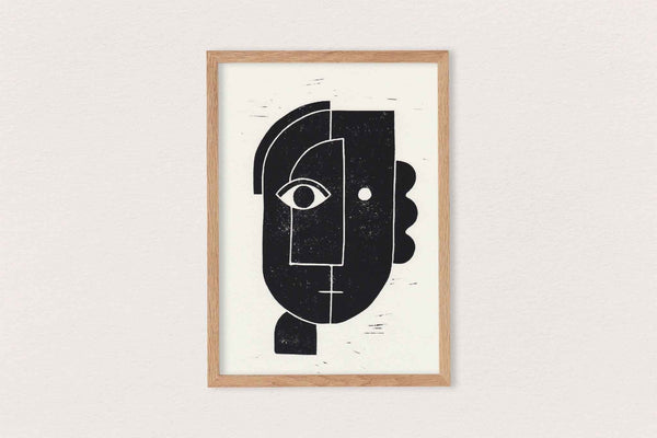 Linogravure encadrée, visage abstrait noir sur fond clair, composition géométrique