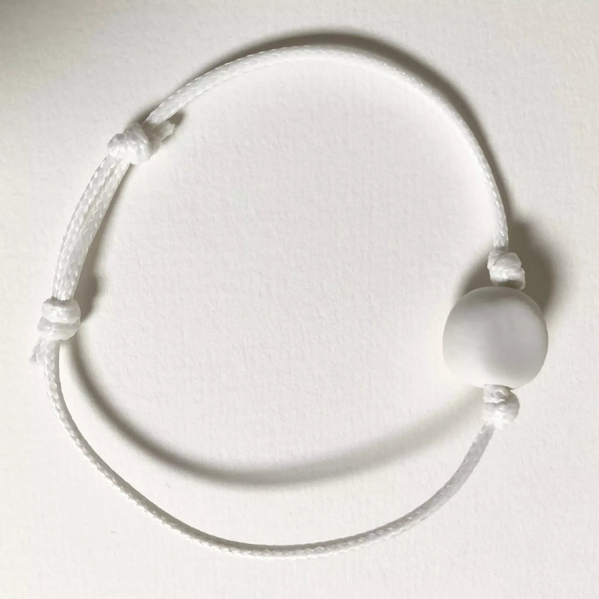 Bracelet cordon blanc avec perle ronde blanche en porcelaine