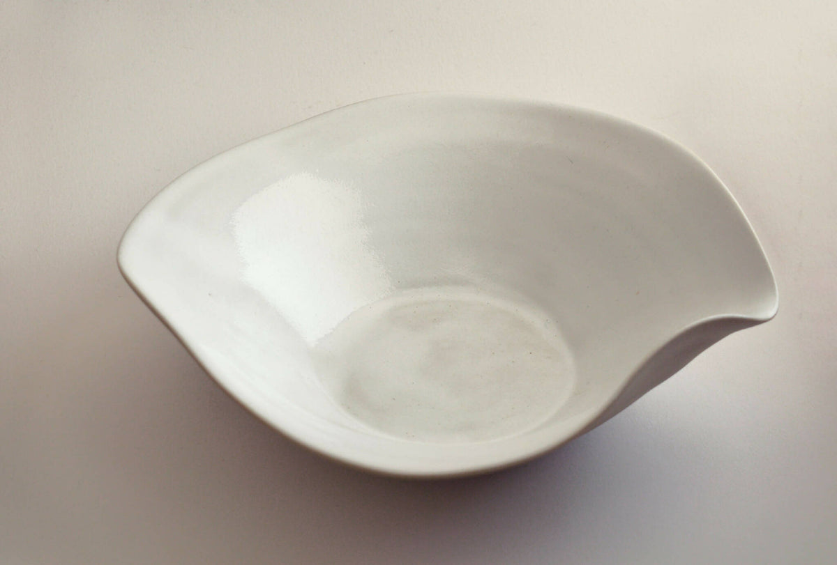 Assiette creuse en céramique blanche, bord ondulé, vue en biais