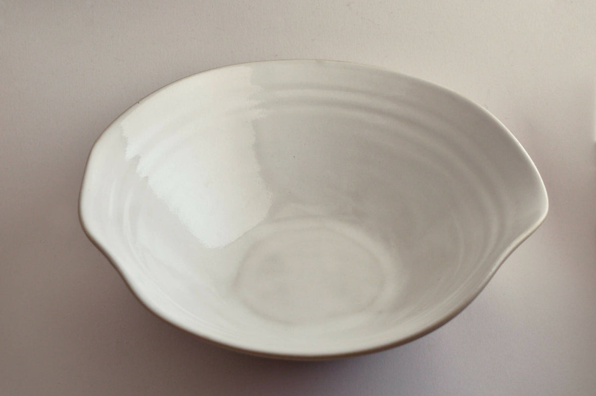 Assiette creuse en céramique blanche, surface brillante, vue de profil