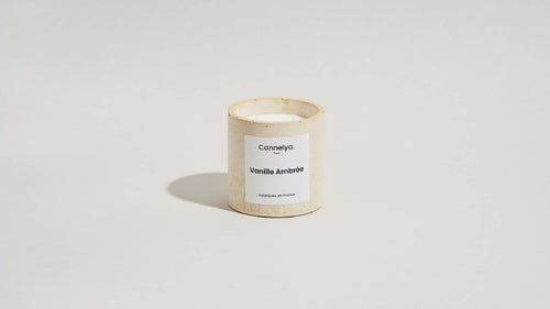 Bougie parfumée Cannelya dans un pot beige texturé, étiquette Vanille Ambrée