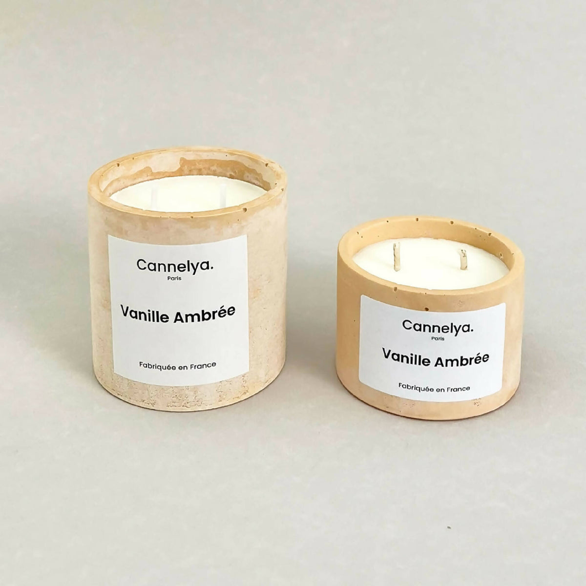 Deux bougies Cannelya Vanille Ambrée dans pots beiges texturés, étiquettes blanches