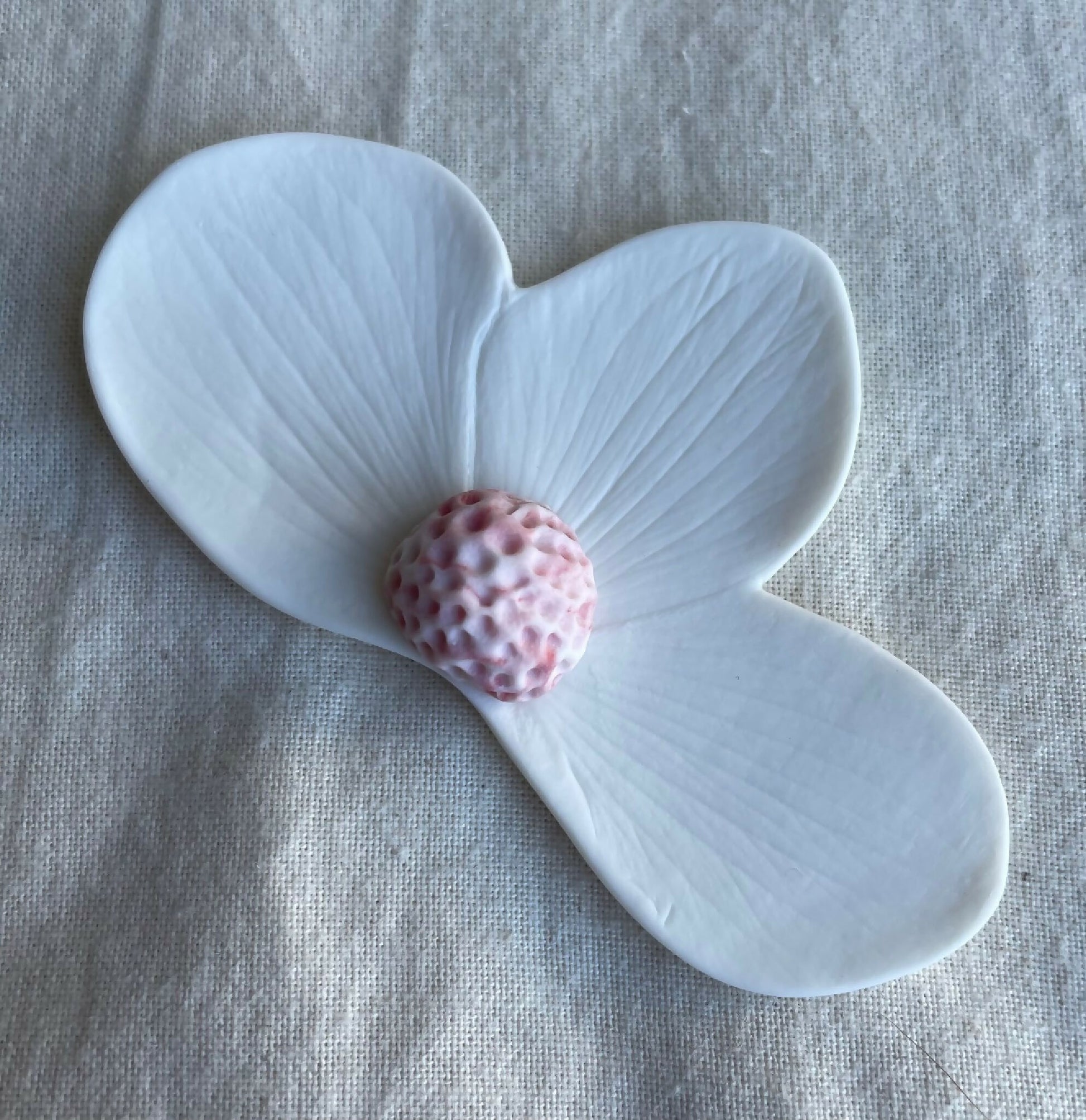 Broche florale en porcelaine aimantée, pétales bleu clair, centre rose tacheté.