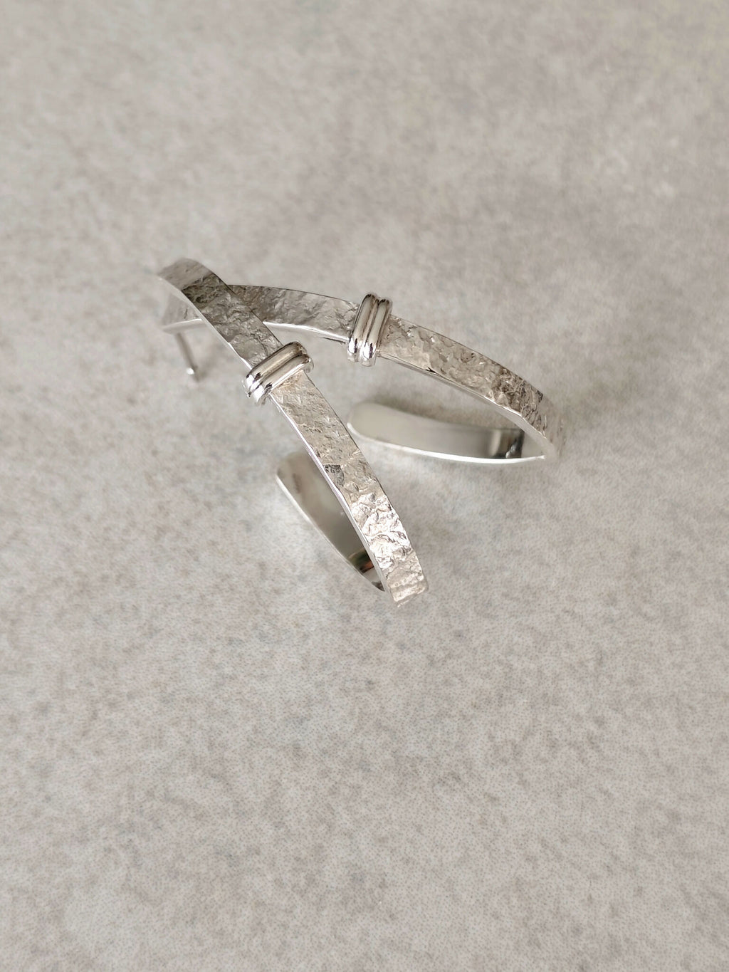 Boucles d’oreilles courbes en métal argenté, intérieur bombé et aspect martelé