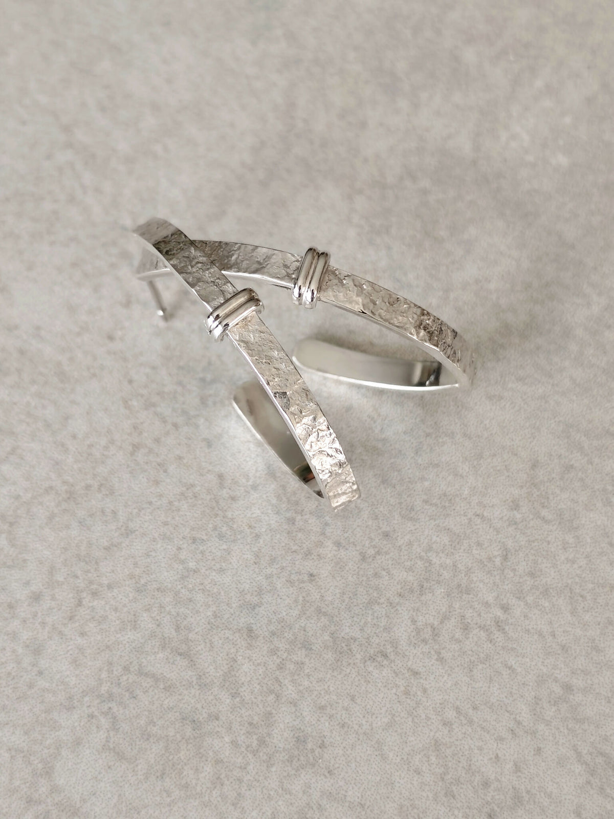 Boucles d’oreilles courbes en métal argenté, intérieur bombé et aspect martelé