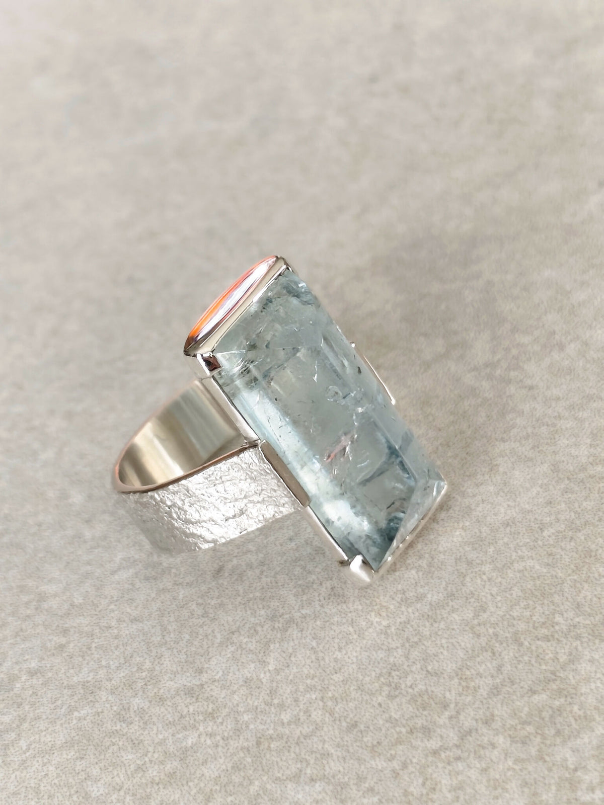 Bague en topaze bleu clair rectangulaire, monture argent, vue de biais.