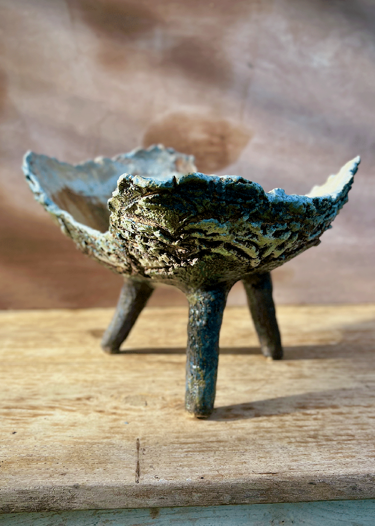 Coupe ou jardinière tripode en céramique bleu-vert, vue de face, bord ondulé et trois pieds.