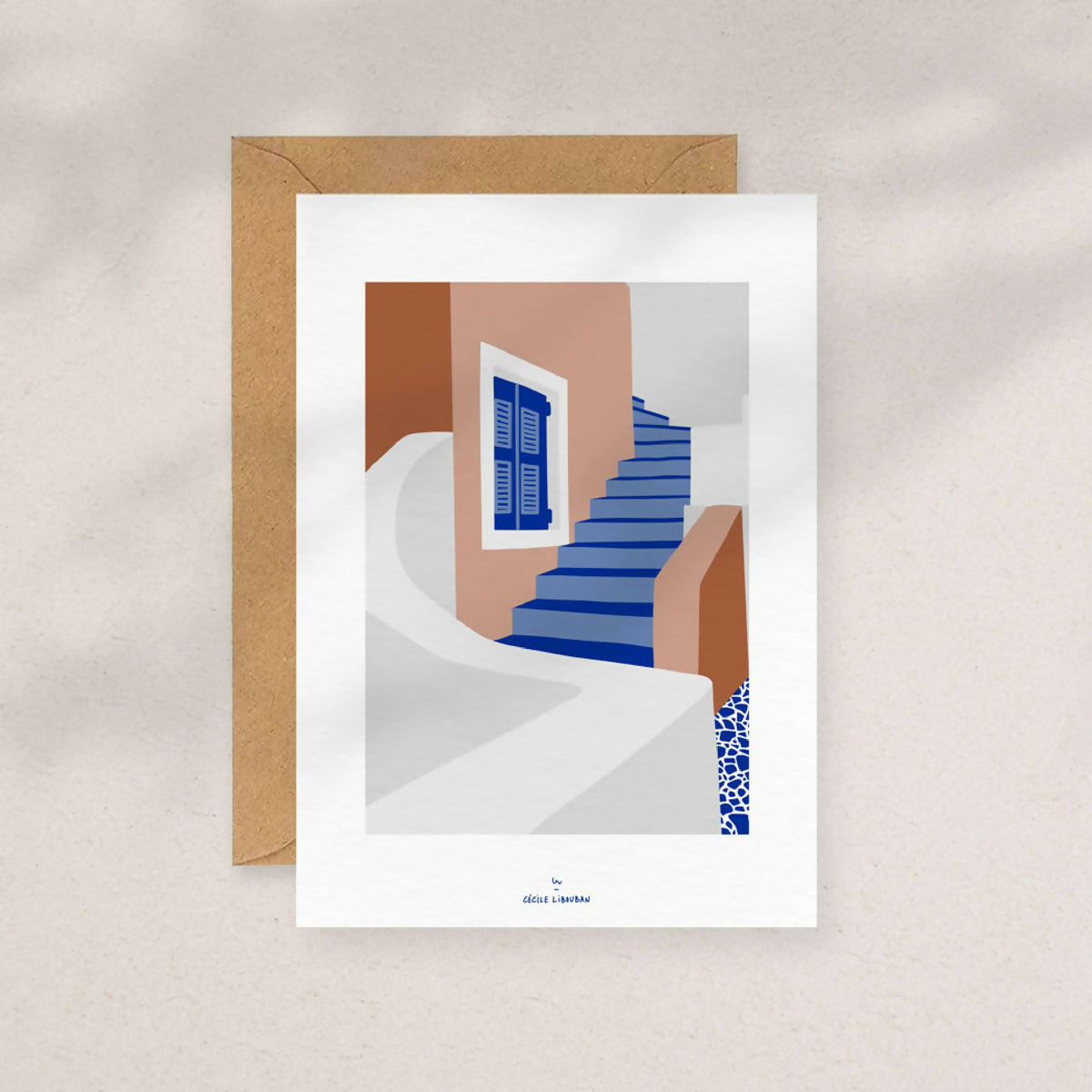 Carte illustrée avec escaliers bleus et façade brun/orange, dans une enveloppe kraft