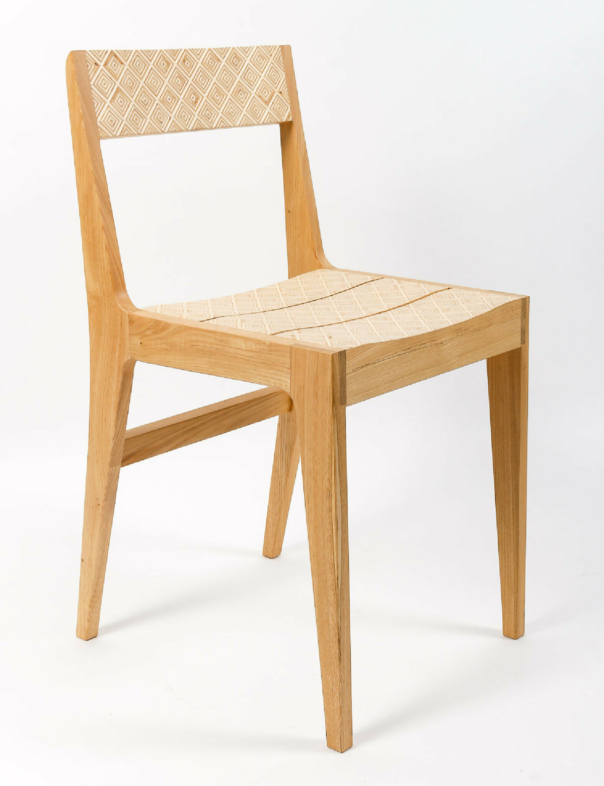Chaise en bois clair avec assise au motif géométrique et dossier ajouré