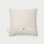 Coussin carré ivoire uni à bouton central, dos sans motif.