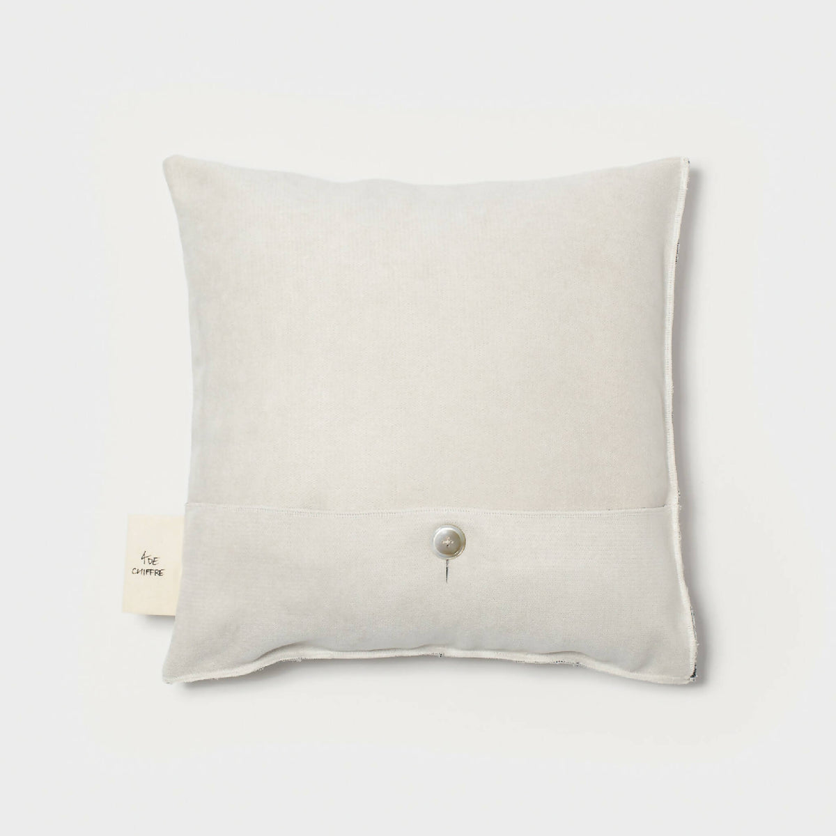 Coussin carré ivoire uni à bouton central, dos sans motif.
