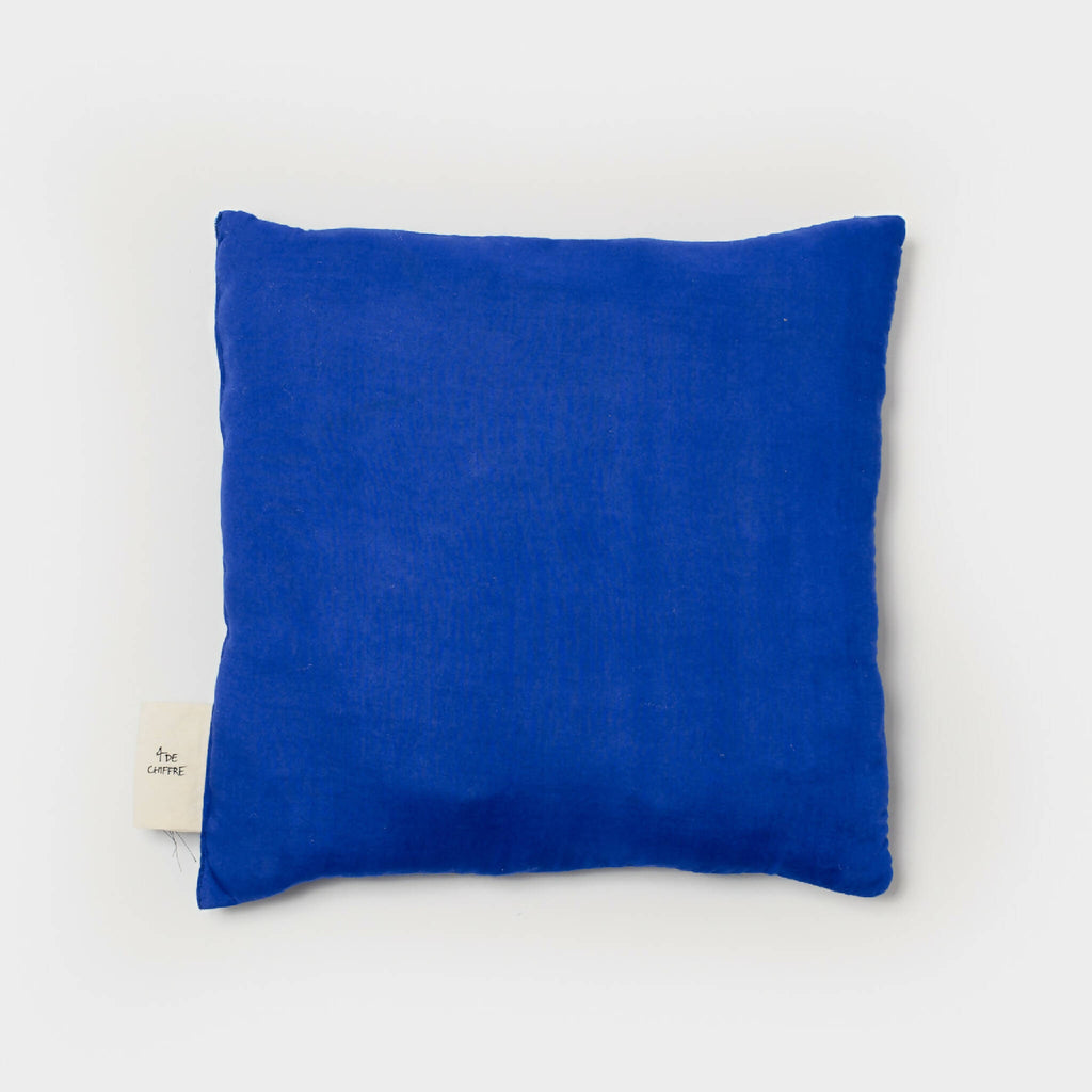 Coussin bleu rectangulaire, vu de face, coutures apparentes et étiquette latérale